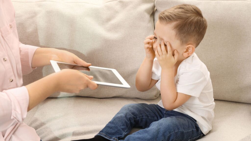 Mother giving her son a tablet to stop from crying