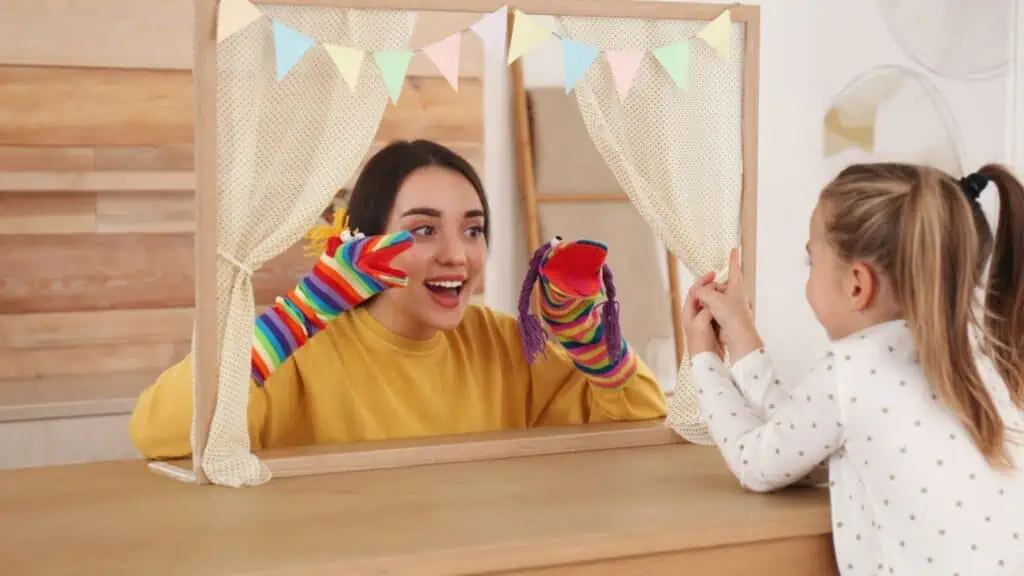 Mother performing puppet show for her daughter at home