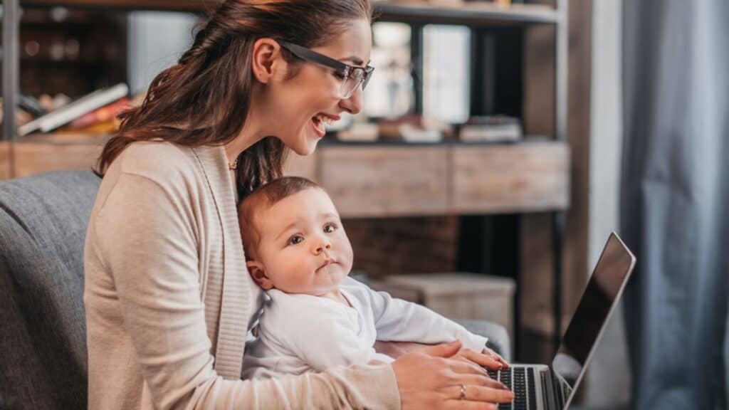 Mother with her son using laptop working at home