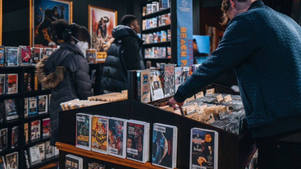 New York, USA - November 25, 2022 Visitors browsing free DVD and VHS rentals at Kims Video in Alamo Drafthouse Lower Manhattan. Kims Video is back in NYC after 12 years in Italy