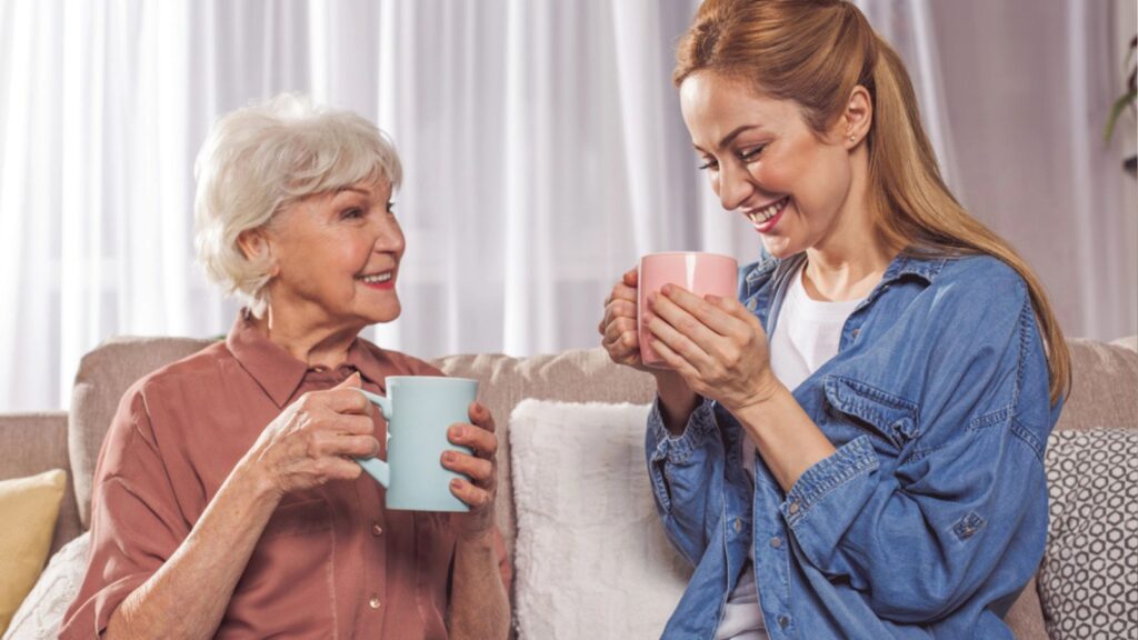 Outgoing grandma and woman drinking beverage