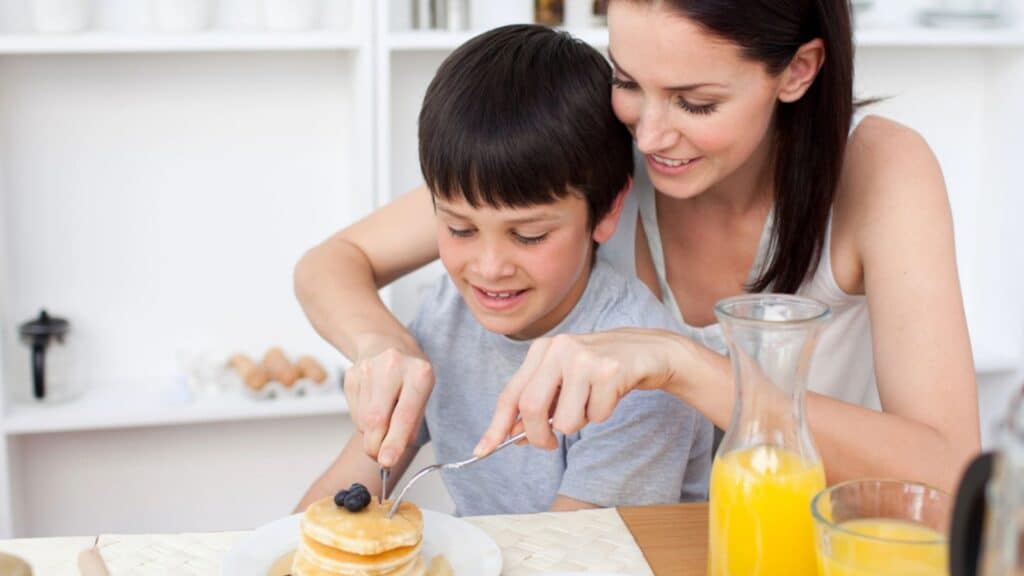 Portrait of a mother and her son eating pancakes for breakfast
