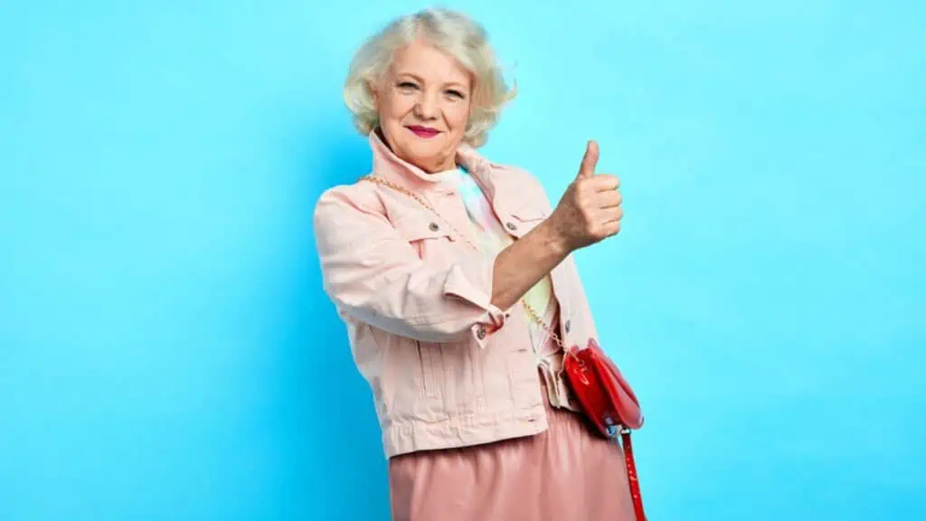 Positive awesome cheerful old lady showing thumb up