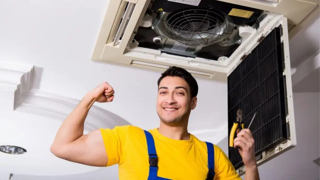 Repairman repairing ceiling air conditioning unit