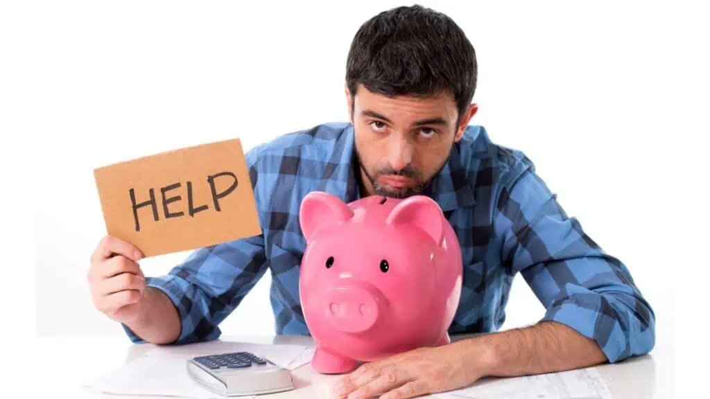 Sad worried man in stress with piggy bank in bad financial situation (1)