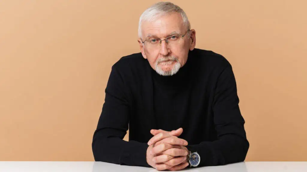 Serious man with gray hair and beard in eyeglasses