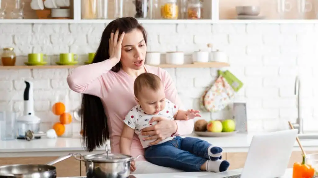Shocked mom with her baby in kitchen at home