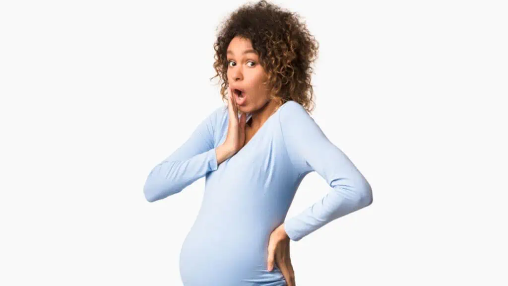 Shocked pregnant woman in white