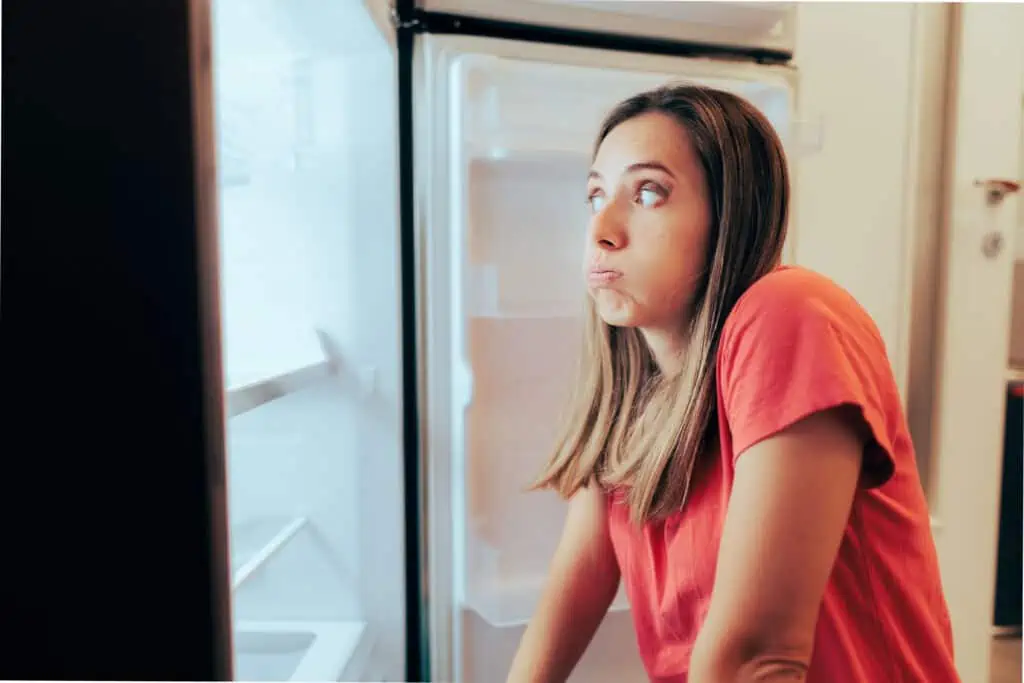 woman standing at an empty fridge