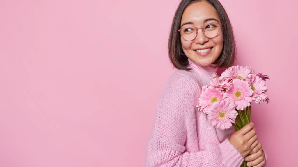 woman holding pink flowers