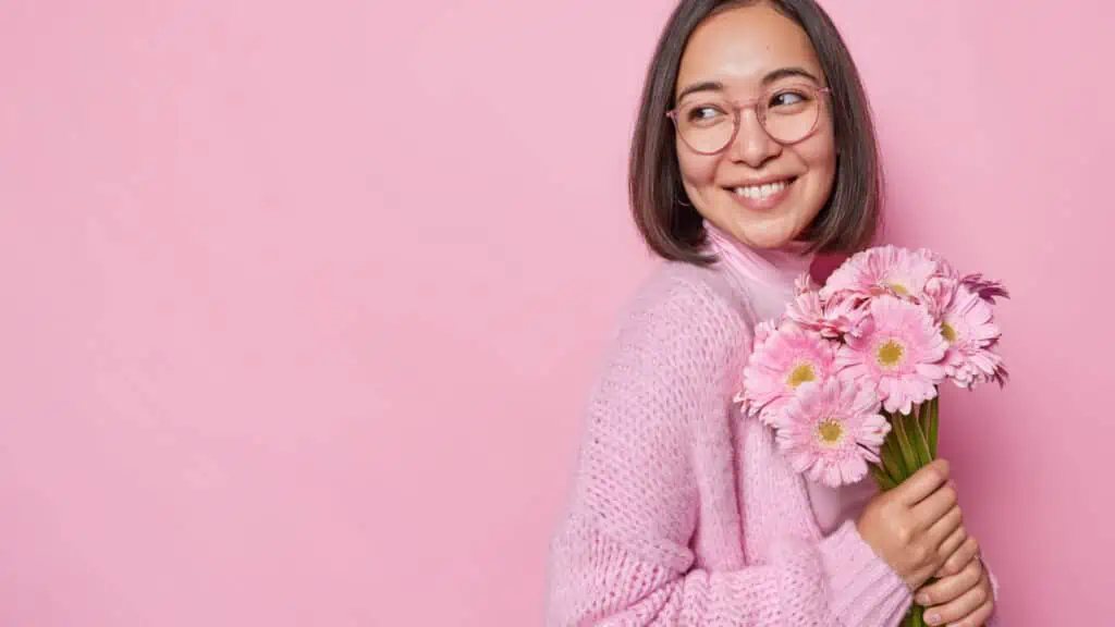 woman holding pink flowers