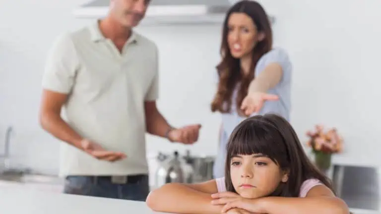 Side view of adult couple having argument at kitchen with a little girl