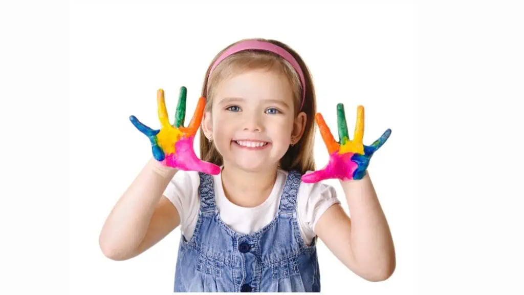 Smiling little girl with hands in the paint
