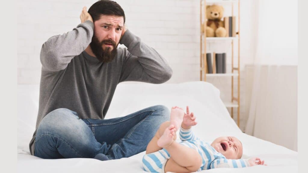 Stressed dad with a crying newborn