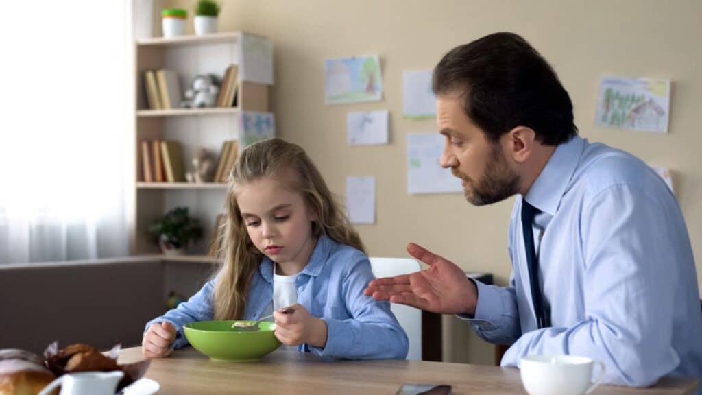 Strict father talking to daughter in kitchen