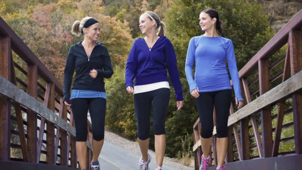 Three attractive young women talking while walking together