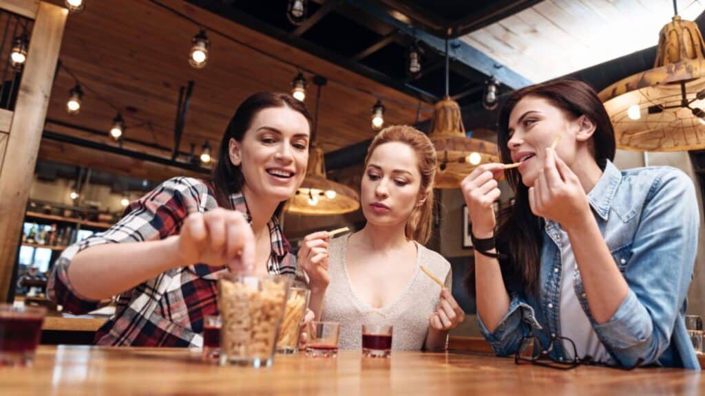 Three woman eating snacks