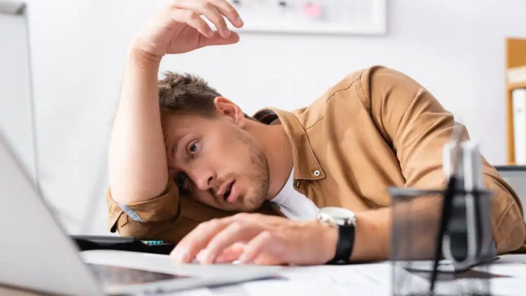 Tired man using laptop