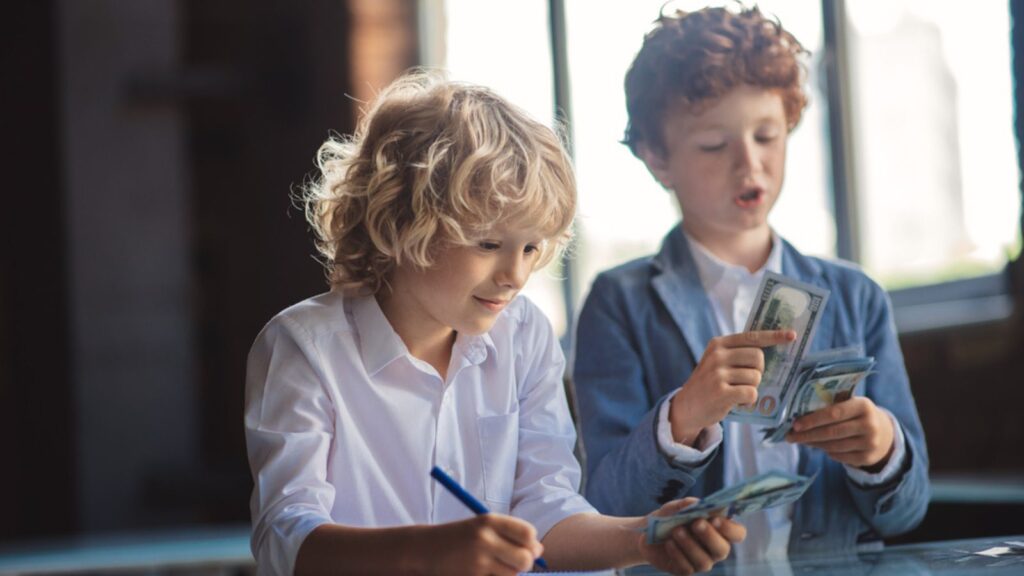 Two boys counting money and making notes