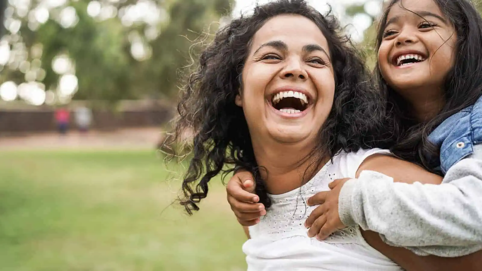 mom laughing with girl outside nature