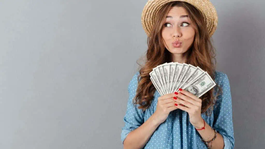 woman holding money with a duck face puckered lips