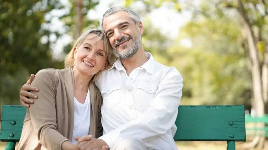 happy couple smiling on park bench