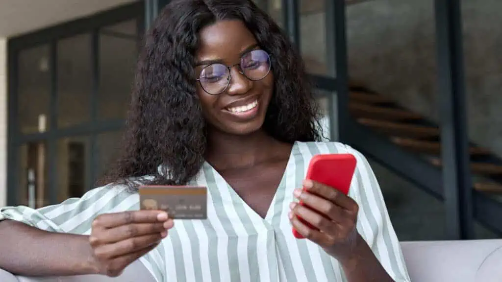 woman paying the credit card on her phone smiling