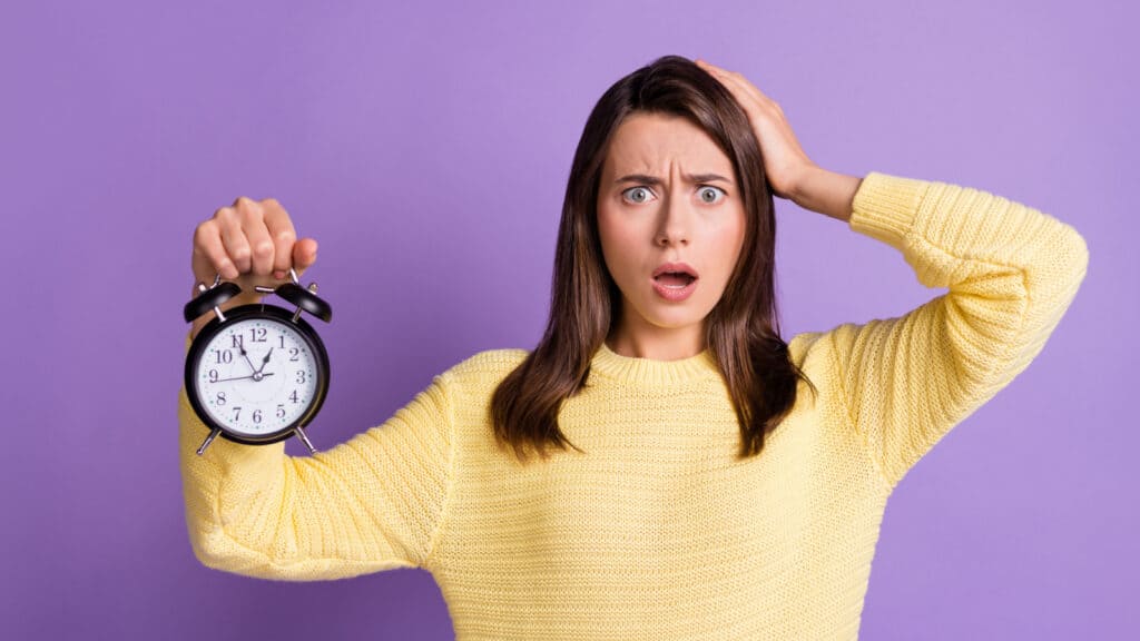 woman holding a clock time shocked