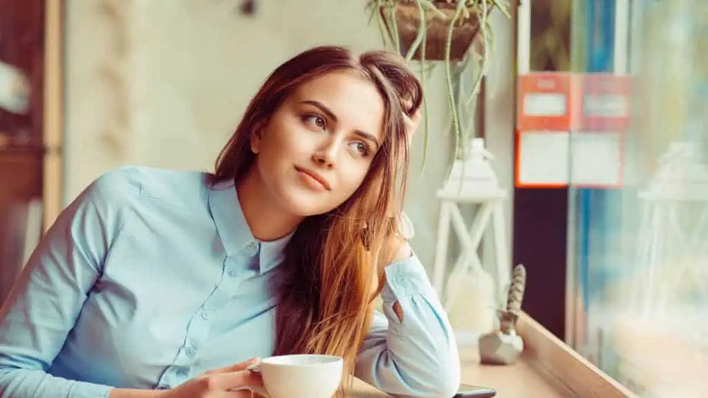 woman at a coffee shop thinking happy content