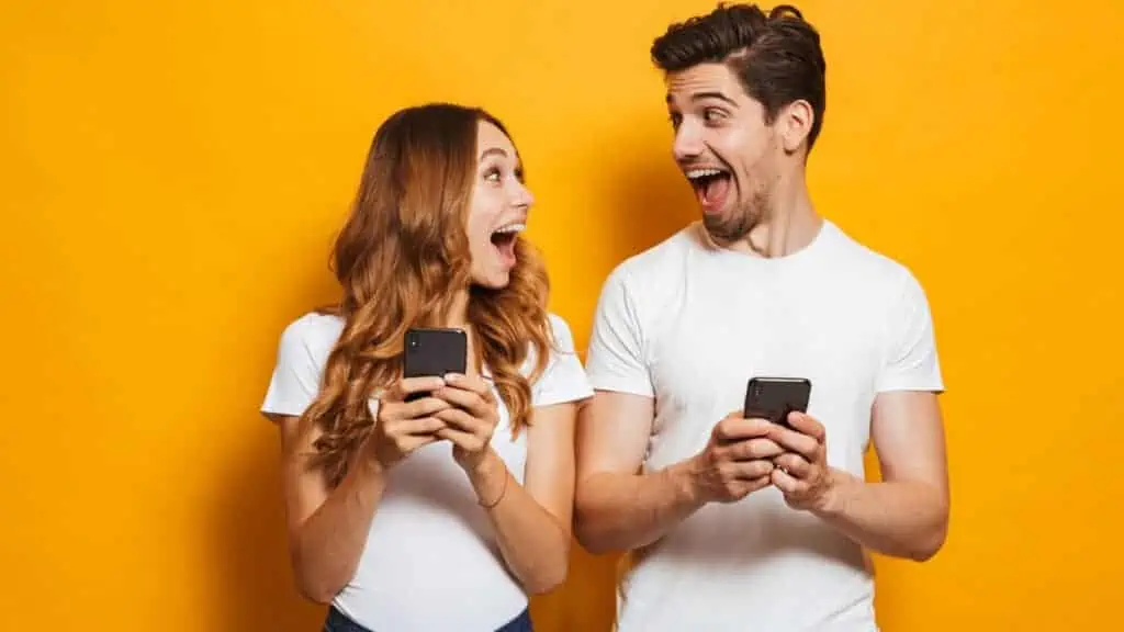 happy couple on phones laughing