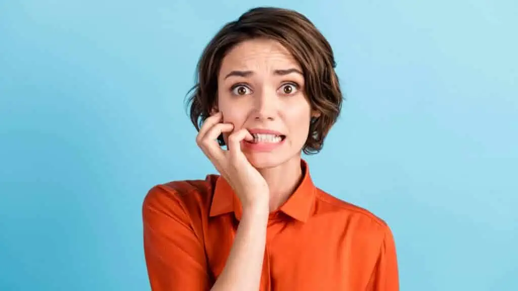 nervous anxious woman biting her nails surprised confused