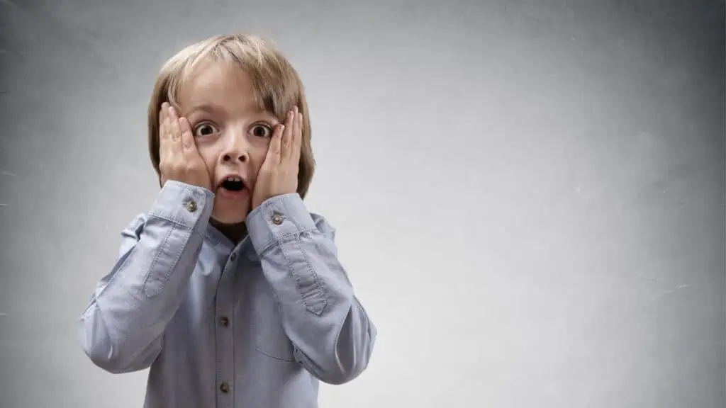 shocked boy with hands on his face