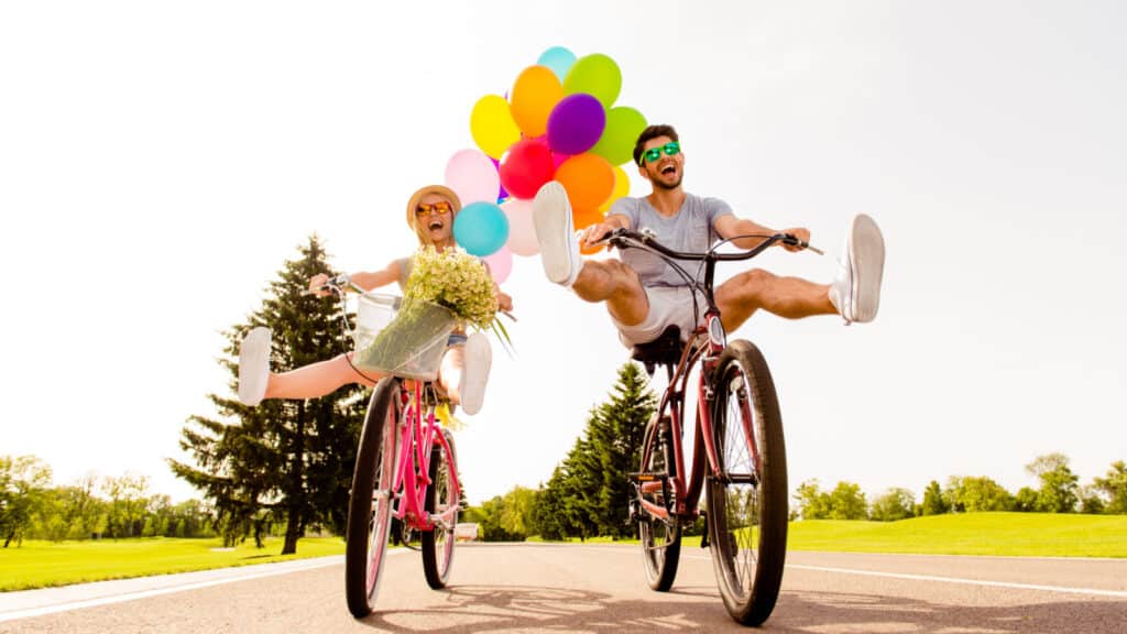 couple on bikes happy outside bikes balloons