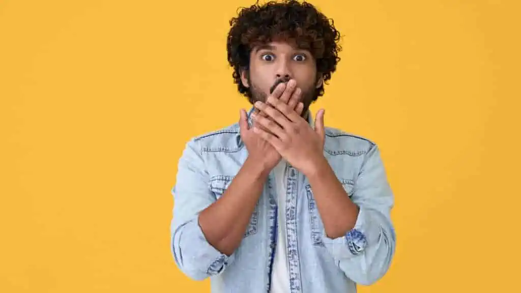 man shocked surprised hands over mouth