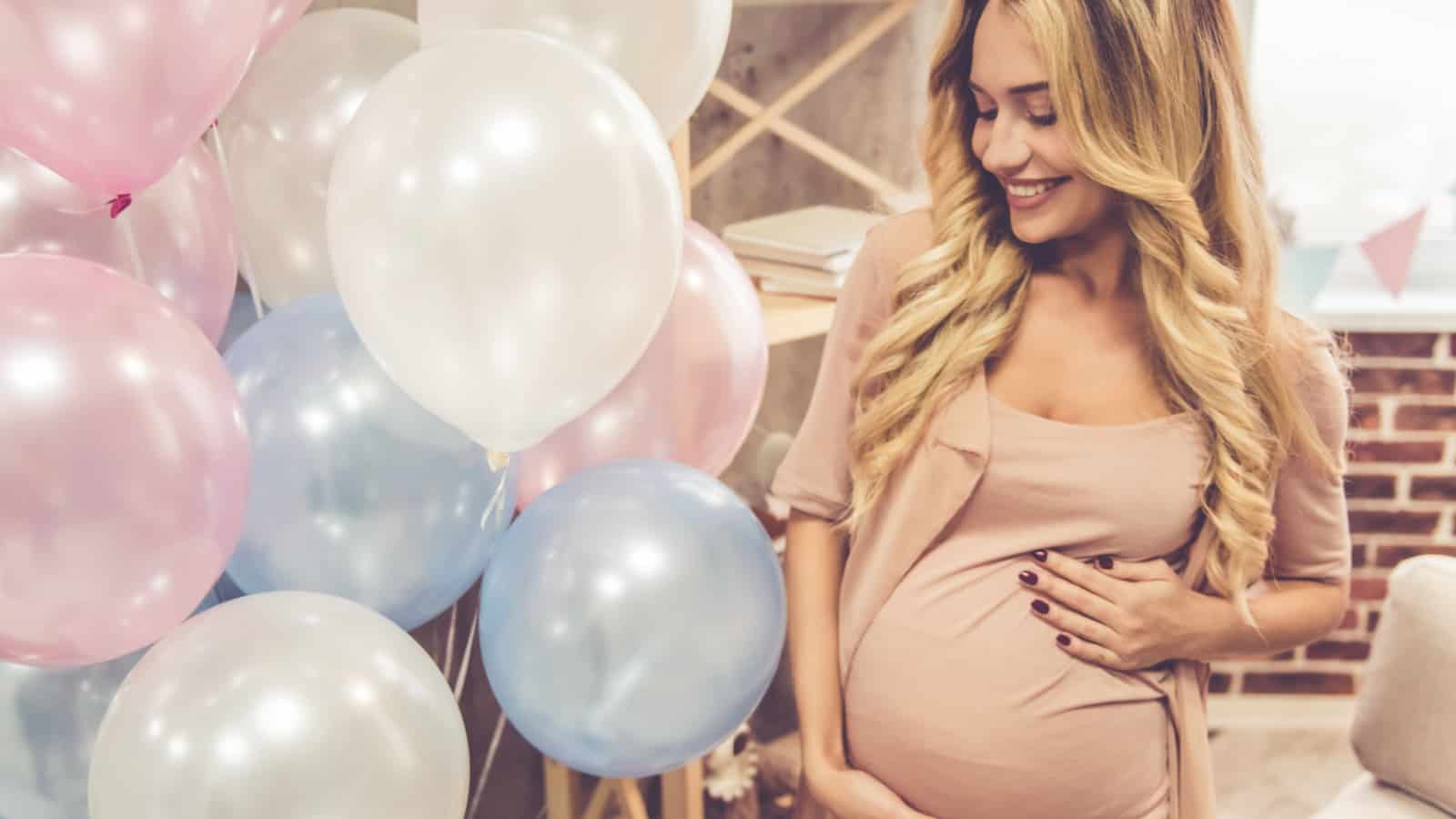 pregnant mom with blue and pink balloons