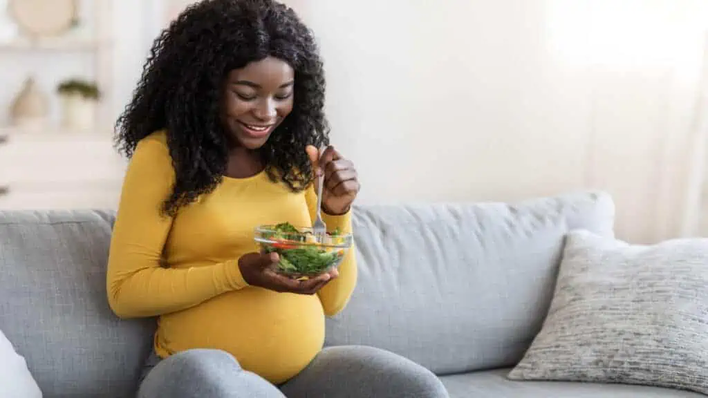 pregnant woman eating salad