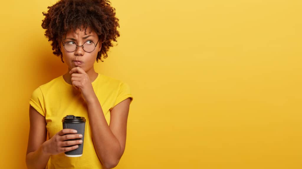 woman thinking with coffee in yellow