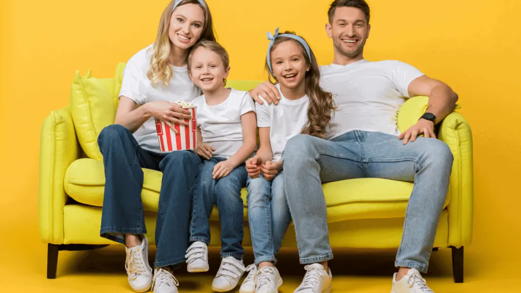 family watching a movie on a couch happy popcorn entertainment