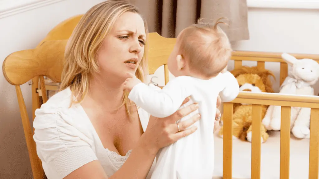 tired mom with baby in the nursery exhausted confused