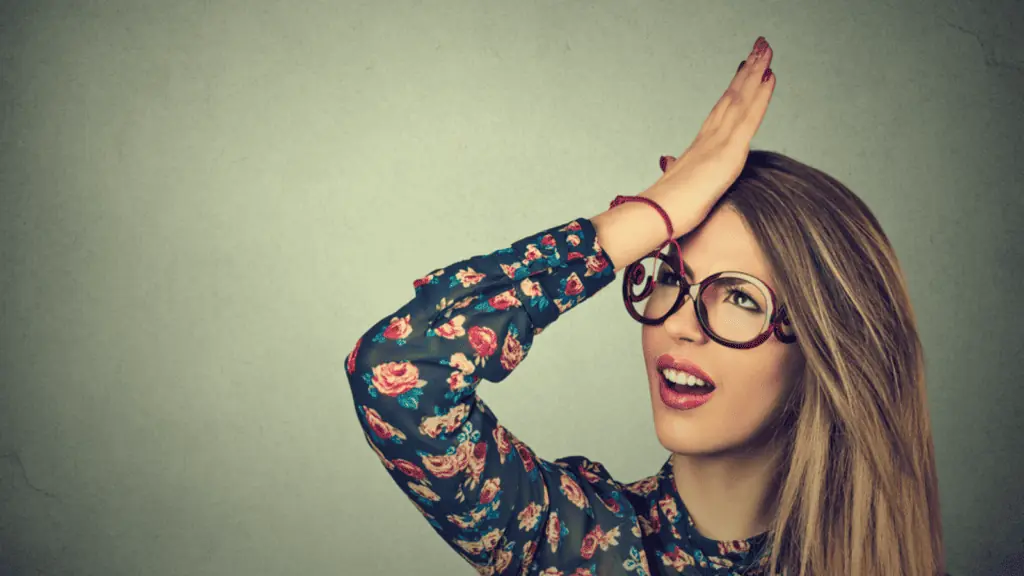 frustrated confused embarrassed woman glasses hand to head