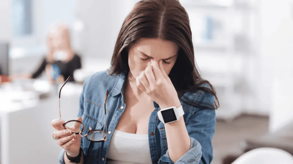 woman frustrated headache office watch