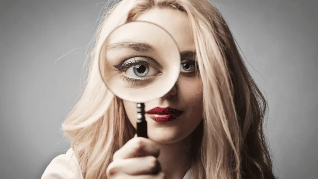 woman looking glass eye investigate confused