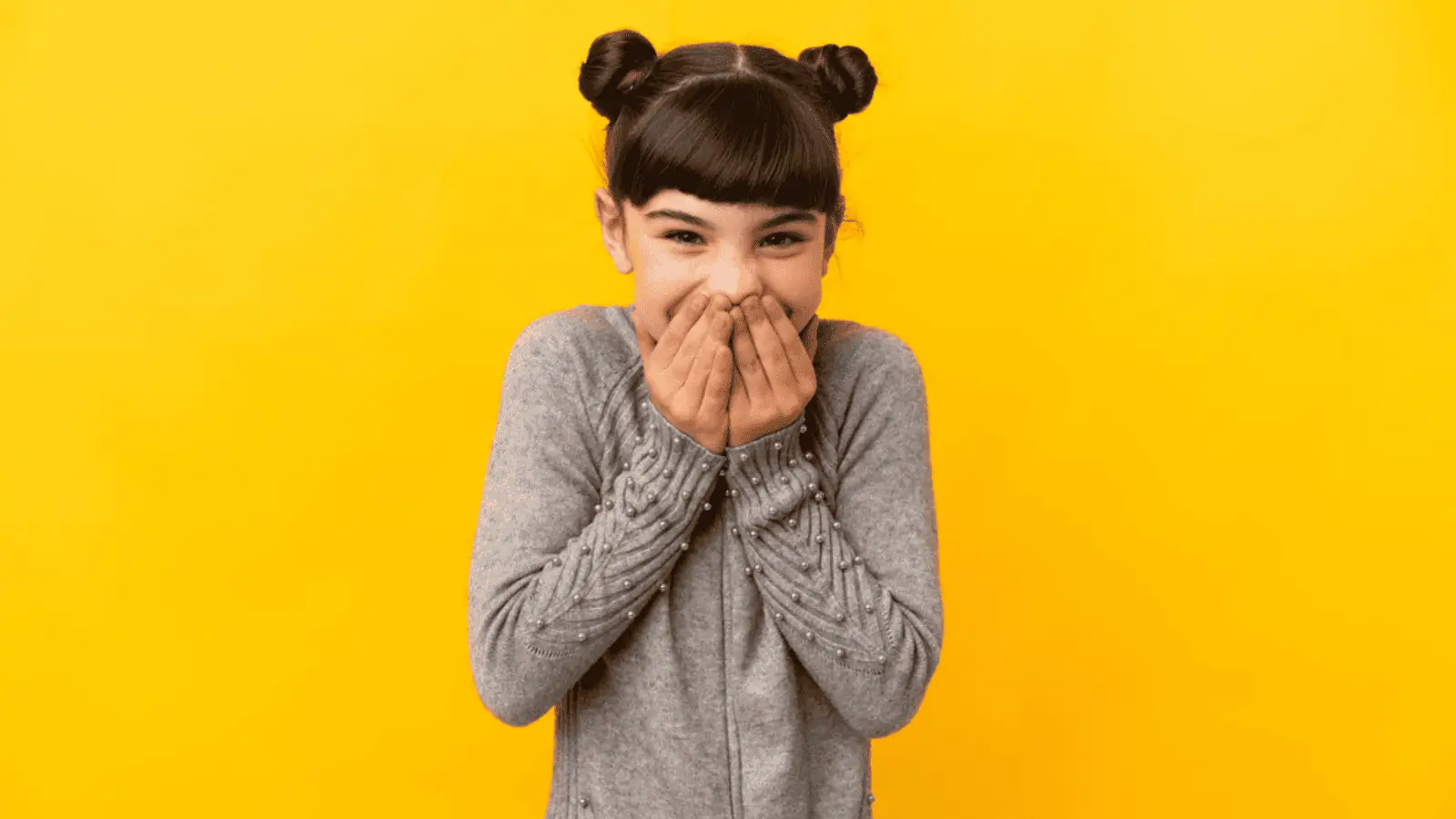 little girl laughing hand over mouth