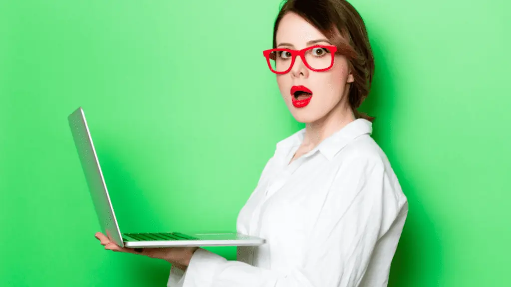 surprised shocked woman red glasses laptop computer green
