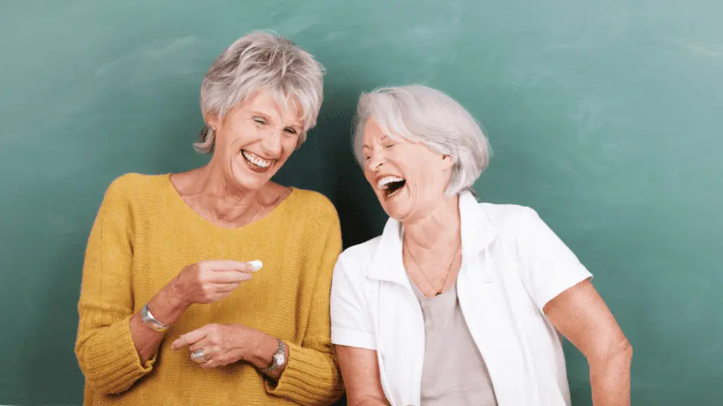 laughing elderly women friends chalk board