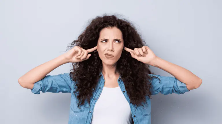 woman plugging her ears frustrated disgusted frizzy hair