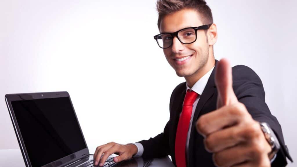happy man at his computer thumbs up glasses