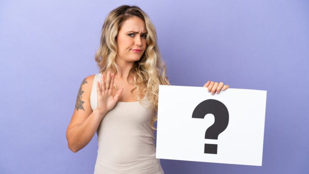 confused woman holding a question mark annoyed