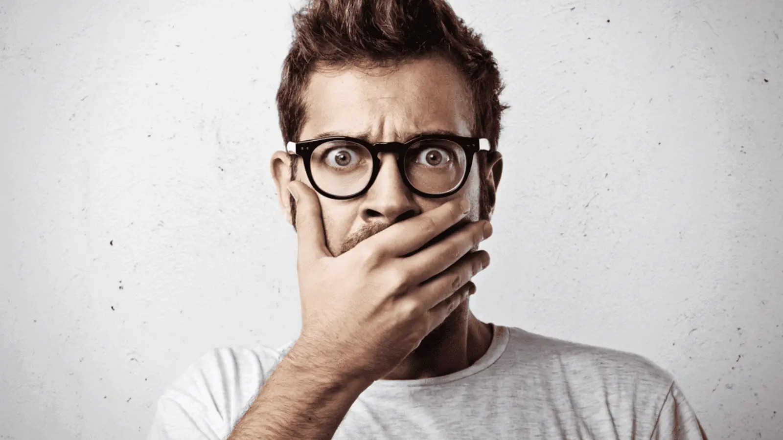 shocked man hand over mouth glasses