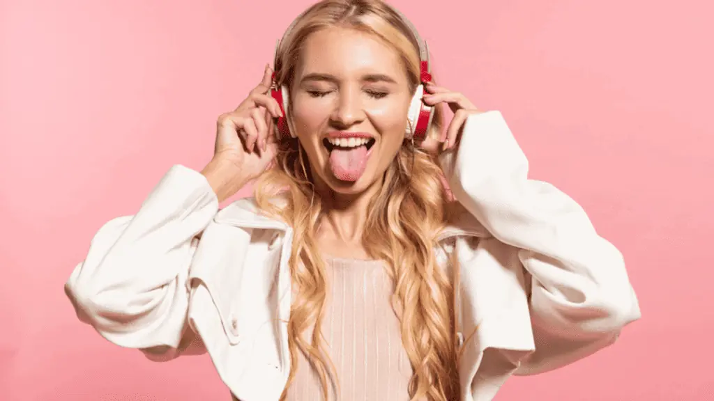 woman listening to music headphones tongue out happy
